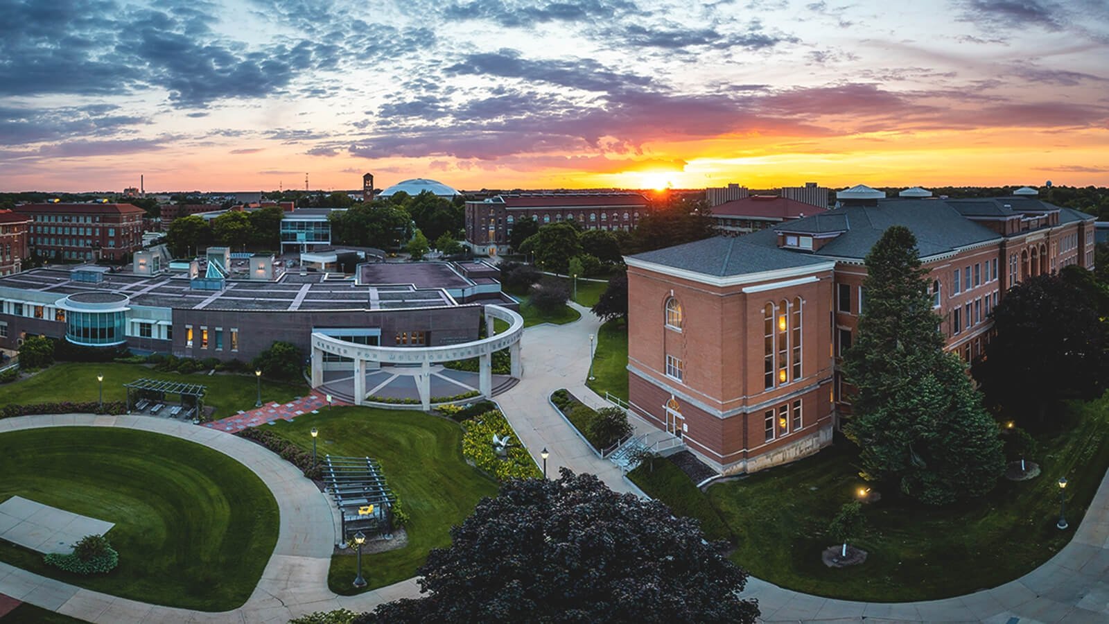 An ariel view of the University of Northern Iowa, including a beautiful setting sun and a variety of campus buildings. 